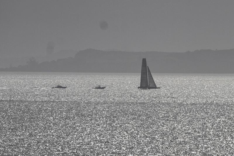 A backlit Defiant (American Magic) foiling on the Hauraki Gulf - Waitemata Harbour - August 23, - 36th America's Cup photo copyright Richard Gladwell / Sail-World.com taken at New York Yacht Club and featuring the AC75 class
