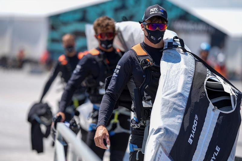 The New Zealand SailGP Team carry their Doyle Sails to the F50 catamaran in the Taranto Technical Area ahead of a practice session. - photo © Thomas Lovelock / SailGP