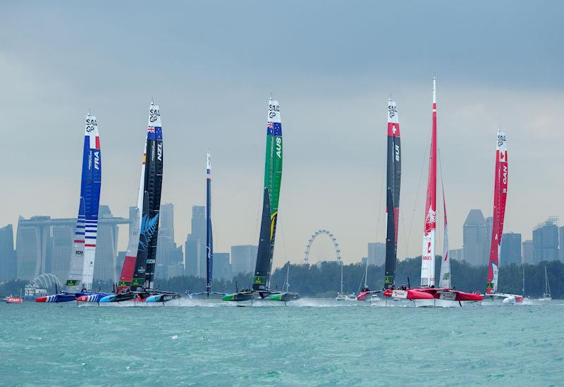 The F50 fleet races towards the start line on Race Day 2 with the Marina Bay Sands Hotel and the city skyline behind themof the Singapore Sail Grand Prix presented by the Singapore Tourism Board photo copyright Bob Martin for SailGP taken at  and featuring the F50 class