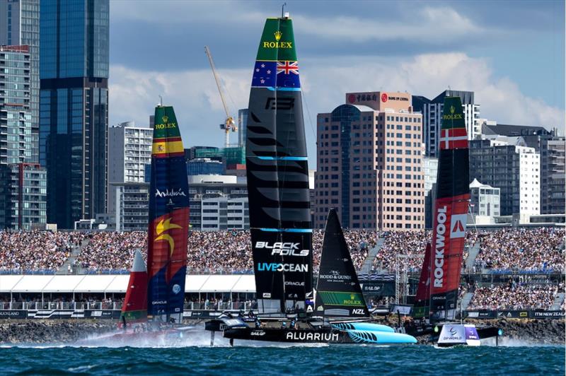 Spain SailGP Team helmed by Diego Botin, New Zealand SailGP Team helmed by Peter Burling and ROCKWOOL Denmark SailGP Team helmed by Nicolai Sehested sail past spectators in grandstand and Auckland city skyline on Race Day 1 of Rolex SailGP Championship photo copyright Felix Diemer for SailGP taken at  and featuring the F50 class