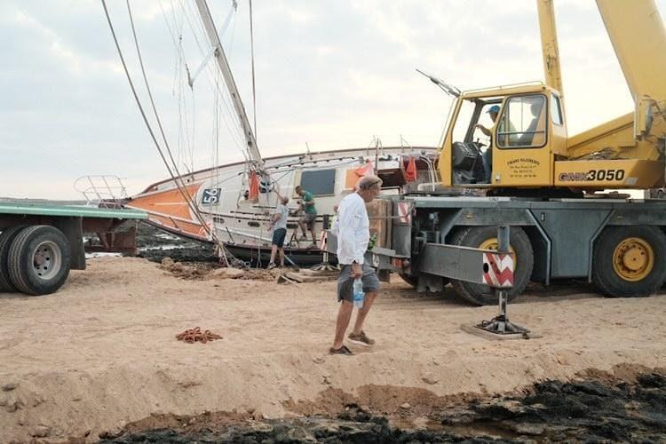 Guy deBoer's walks in front of Spirit, now off the beach and in the yard in Fuerteventura, ready for repairs and re-launching photo copyright Laerke from Mara Noka! taken at  and featuring the Golden Globe Race class