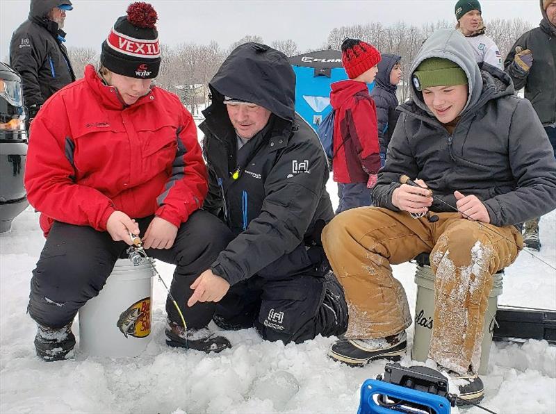 Volunteer Mike Rodger (center) of Cement Masons Local 633 offered ice fishing tips to a pair of young participants photo copyright Union Sportsmen’s Alliance taken at 
