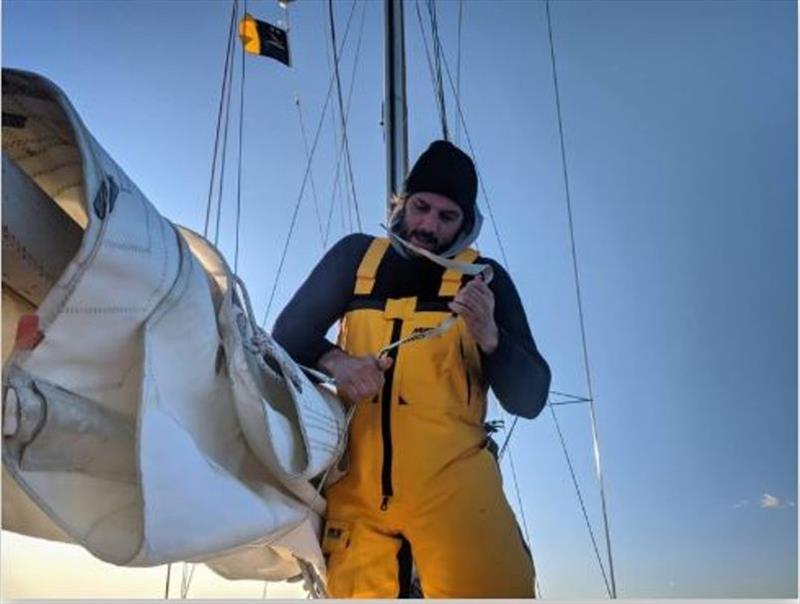 Bill putting the mainsail away after a cold transit photo copyright Ocean Cruising Club taken at 