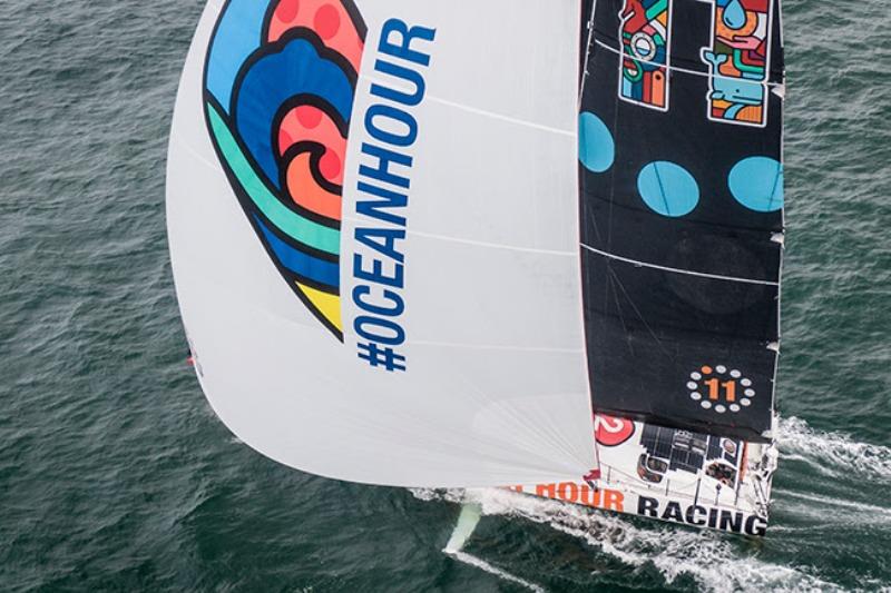 11th Hour Racing Team's vibrant IMOCA 60 sailing off the coast of Concarneau, France photo copyright Amory Ross / 11th Hour Racing taken at  and featuring the IMOCA class