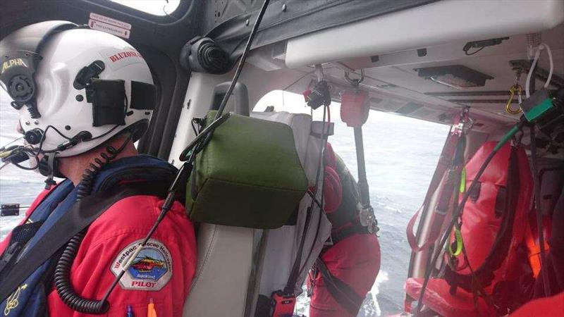 Chief Pilot Roger Hortop with a crew member preparing to assist one of the rescued sailors into the Auckland Rescue Helicopter Trust aircraft - photo © Auckland Rescue Helicopter Trust