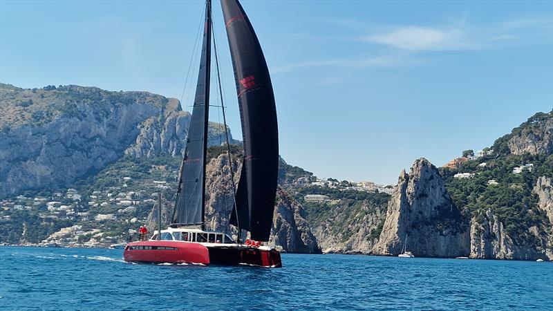 Lord Irvine Laidlaw's Gunboat 80 Highland Fling 18 passes the Faraglioni rocks en route to winning the race around Capri at the IMA Maxi Europeans photo copyright James Tomlinson taken at Circolo del Remo e della Vela Italia and featuring the Catamaran class